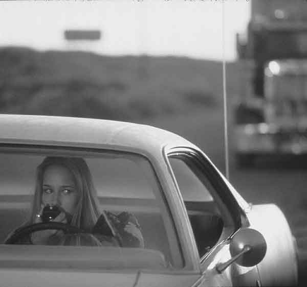 Image: "Squelch" eases college blues:Leelee Sobieski eyes a foreboding truck that has been following her in "Squelch." (Photo by Merie Wallace Twentieth Century Fox):