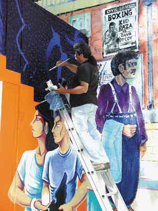 Image: Mural gets new life:Sac State alumnus Juanishi Orosco does a little touch-up work Monday afternoon.: