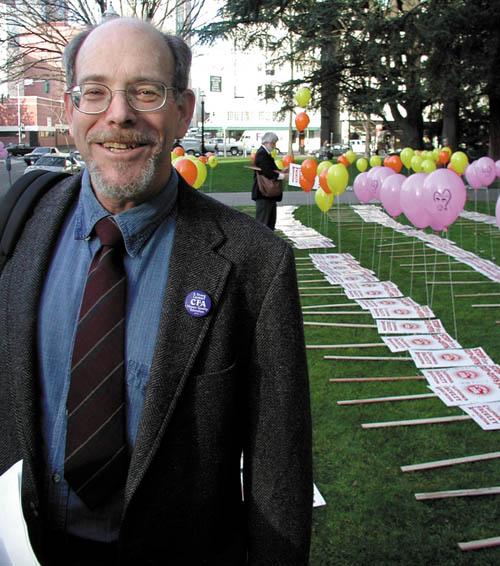 Image: Rebel with a cause:Jeff Lustig stands near a row of picket signs and balloons last February prior to a California Faculty Association demonstration at the Sutter Club. Lustig is stepping down as CFA president later this month. Photo by Barrett Lyon/State Hornet: