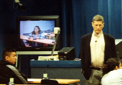 Image: Merits of web and TV classes stir debate :Professor Robert Friedman lectures to his government class in a campus studio and via television. Opinions differ on whether distance learning classes like this one help or hurt students.Photo by Yvonne Garcia/State Hornet: