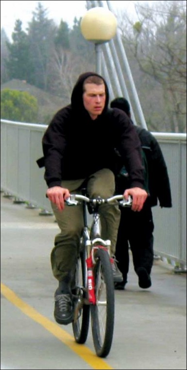 Image: Cruisin to campus:A Sac State student cruises by foot traffic on Guy West Bridge en route to class. :