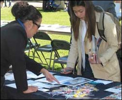 Image: Students choose grad school over shaky job market:A University of the Pacific representative points out details from a brochure to freshman biology major My Nguyen at the Graduate Fair in the Library Quad on Thursday. - Photo by Kathy Bustillo: