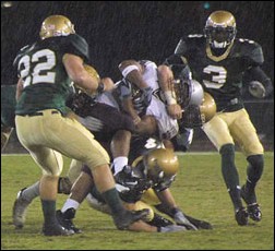 Image: Pain in the Rain:Montanas Justin Green, tackled by Ryan Kroeker with Ramon Payne(3) and Matt Logue (22) in pursuit, scored the first touchdown. -- Photo by Kim Park/ State Hornet:
