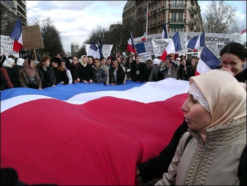 Image: French Muslims protest banning of Hijabs:Veiled women holding the French flag march in protest Saturday, Feb. 7, 2004, to the Assemblie Nationale, the French equivalent of the United States House of Representatives, in central Paris. Hundreds marched to protest the new French law banning most re: