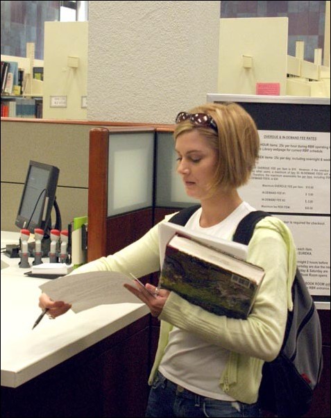 Image: Required books often not needed:Students like Kim Parker can check out textbooks from the Librarys Reserve Book Room for two-hour periods.:John Grix/State Hornet 
