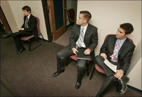 Image: Capped, gowned and hired:Dressed for success, University of Kansas students Brandon Trice (from left), Tom ODea and Ari Shapiro waited for job interviews last month at the University Career Center in Lawrence, Kansas. Experts say many companies are offering incentives to new gr: