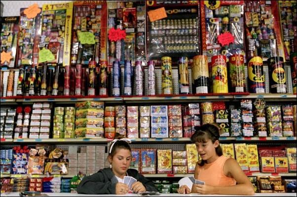 Image: Save your digits, leave fireworks to the pros:(KRT)Jaime Wimberly, left, and Haley Cunningham play cards while waiting for customers at the Texas Giant fireworks megastore near Weatherford, Texas, on Monday, June 25, 2001. Photo Courtesy of Allison V. Smith / Dallas Morning News. :