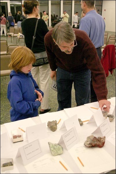 Image: Fossils, rocks bring enthusiasts to Geology Club auction:Kevin Cornwell, a faculty member in the Geology Department, shows off some of the items up for silent auction to his daughter Hannah during the Geology Clubs Rock Auction held in the Alumni Center on Friday night. Photo by Lisa Filbert/The State Horn: