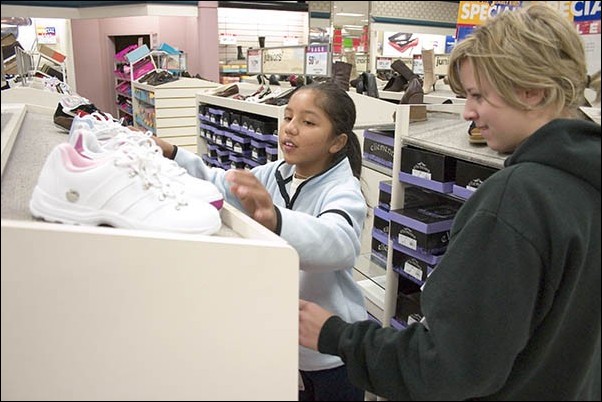 Image: Greeks bring warmth to needy families:Sac State Delta Gamma sorority member Anna Cheechov helps a girl pick out a new pair of shoes at Mervyns in Rancho Cordova on Saturday morning. The shopping trip was a joint effort between Delta Gamma and the 20-30 Club of Sacramento.:Ken McFarland