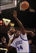 Wyomings Justin Williams slaps the ball away from Air Force Academys Dan Nwaelele (34) in first half action during the Mountain West Conference tournament. Wyoming defeated Air Force, 75-55, on March 9, 2006 at the Pepsi Center.:Kevin Kreck