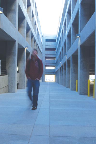 A student walks down a narrow path in the newly opened Parking Structure III.: