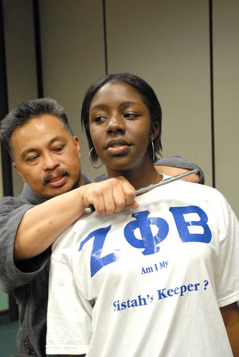 Instructor Ed Bansuelo teaches students how to handle knife attack at the Zeta Phi Beta Self Defense Forum on Thursday. Senior social work major Shamanicka Boykins helps demonstrate.: