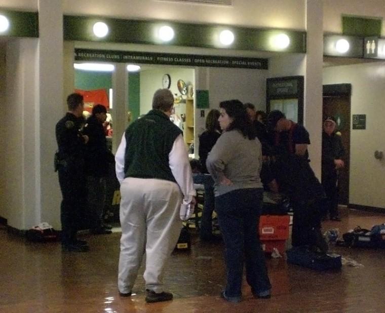 University Union Director Leslie Davis and others look on as paramedics tend to the victim.: