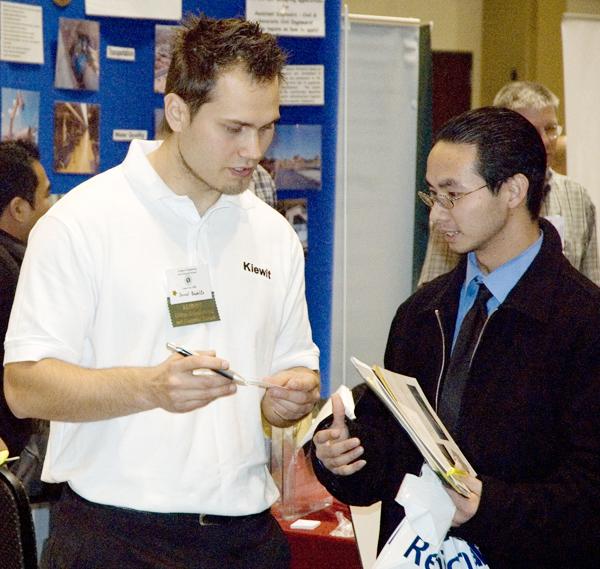 Kiewit representative Daniel Badelita, left, and student Luan Dang, right, discuss employment possibilities at the Engineering and Science Career Fair on Monday in the University Union.:
