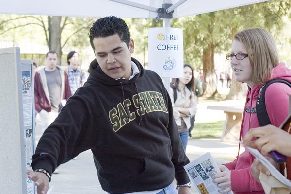 Executive Vice President Miguel Cervantes (left) talks to a student, senior Jane Hurley (right), about ASI activities and future events. Cervantes discussed the contributions of student government throughout the morning as part of Coffee and Conversation.: