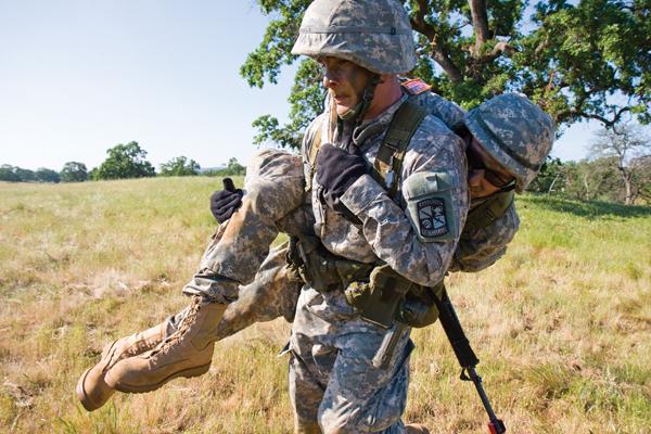 Sac State criminal justice major Chance Hoggle carries wounded international relations major Jack Zwald during a combat simulation at the ROTC field training exercises in Spenceville on Saturday.: