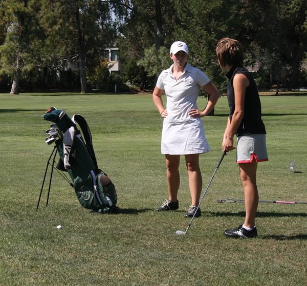 Media Credit: Jennifer Lemos - Assistance coach Kim Coppin helps Annie Becker with her swing from the rough to the green at the Valley Hi Country Club.: