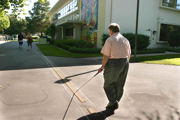 Sacramento State Disability Management Counselor Gene Lazano uses his cane and yellow guide strips to navigate his way around the Sac State campus.: