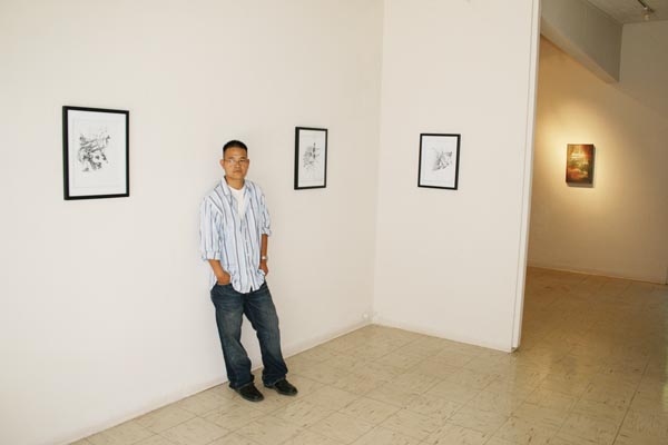 Art major Essee Vang stands in front of one his favorite drawings during his art show at the Witt Gallery.: