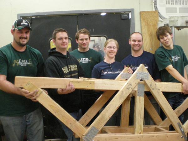 Members of the civil engineering team pose with the truss bridge they submitted as their project in the competition.: