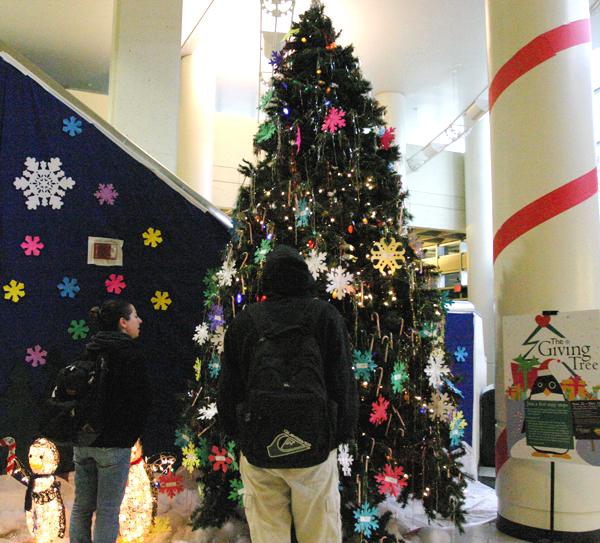 The Giving Tree, located on the University Unions first floor, is part of the annual Childrens Toy Drive. The drive will benefit Sunburst Projects, which serves children and families living with HIV/AIDS. Each toy request, in the shape of a snowflake, is a mini wish list that ranges from gift cards to iPods.: