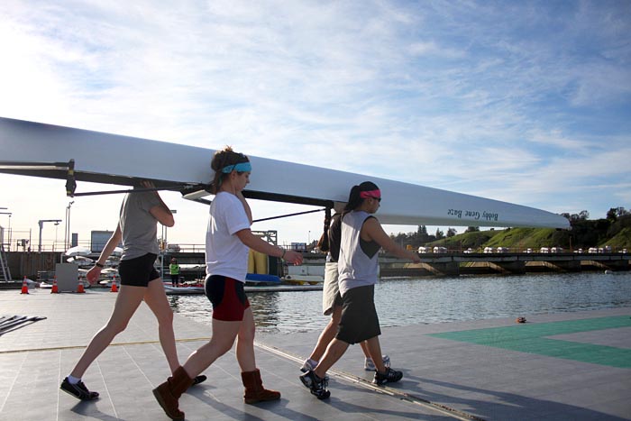 Members of the Varsity Rowing Team make their way out to the docks of the CSUS Aquatic Center to launch their boat for training on Friday afternoon.: