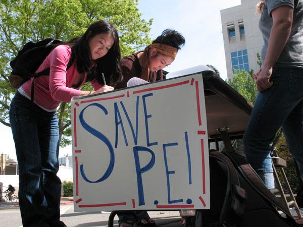 Students stand outside Yosemite Hall signing petitions against bills which would change physical education requirements. :