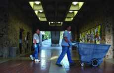 Facilities workers Jack Connor, left, and Gary McDaniel, right, walk through Eureka Hall during work. :