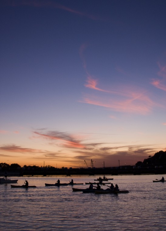 Kayakers paddle around Lake Natoma during sunset.: