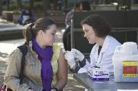 Megan OLeary gives Aigline Elle Olivier, a senior foreign exchange student from Australia majoring in Business, a flu shot in the library quad on Wednesday.: