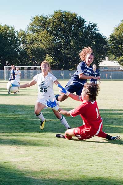Womens Soccer vs. UCD 1:Hornets forward Leah Larot and Aggies goalkeeper Kathleen Brandl go after the ball at the same time during a game against UC Davis on Friday at Hornet Soccer Field. The Hornets lost to the Aggies 1-0.:Robert Linggi - State Hornet