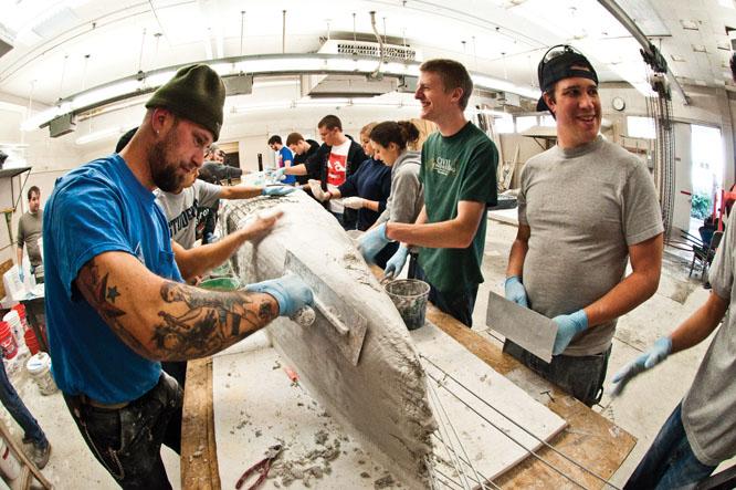 Concrete Canoe Club:Civil engineer juniors Dave Harden, Adam Youngson and senior Jeff Riley shape the outside of their legendary concrete canoe while having a laugh.:Jesse Charlton - State Hornet