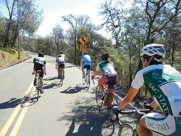 The Cycling Team bikes down a path near Folsom Lake during a practice ride.