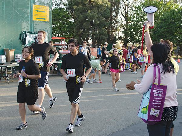 Spectators cheer for runners at the finish line of the Sac State 5K Fun Run on Thursday.