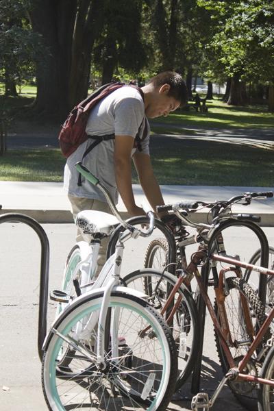 Raul Jimenez, sophomore graphic design major is locking his bike
near the Eureka Hall bike racks on Sept. 6. Jimenez is among many
other Sac State students who make sure their bike is secure and
locked.

