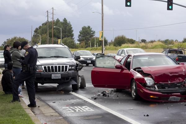 At a four-car accident on College Town Drive, Matthew Light of
the Sacramento State Police Department blocks traffic and collects
information from all the students involved with the accident.
