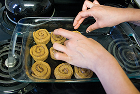 Janice Daniels, features writer for The State Hornet, arranges
her pumpkin cinnamon rolls in a pan before baking them.
