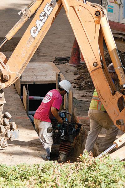 Workers finish packing down the dirt as they work on the water
relocation project.
