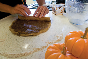 Janice Daniels, features writer for The State Hornet,
demonstrates how to roll her homemade pumpkin cinnamon rolls, a
tasty Halloween treat.
