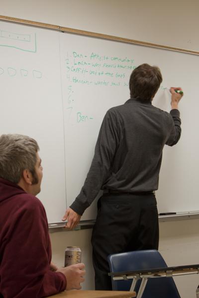 Ben Hoyt, senior history major, writes the line-up of speakers
during a meeting for their "Ask an Atheist" event on Thursday. 
