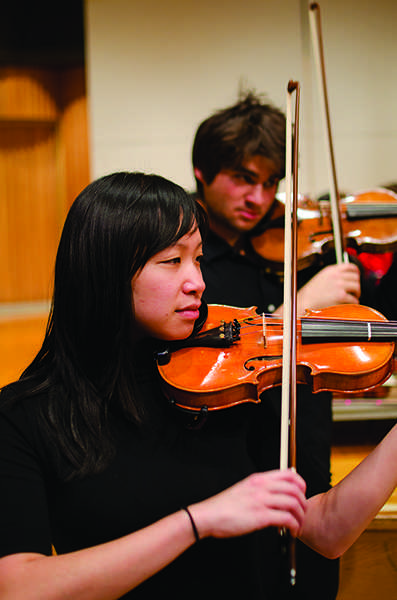 Graduate student Jennifer Jim plays second violin during
rehearsal in Capistrano Hall.
