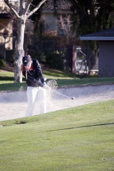 Junior Kercia Brakel lofts her ball out of a sandtrap at Valley
Hi Country Club.
