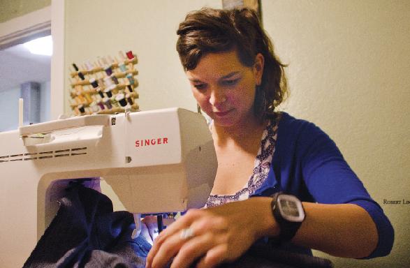 Hannah Hicks, designer for PLDM, works on a pair of women’s
jeans.
