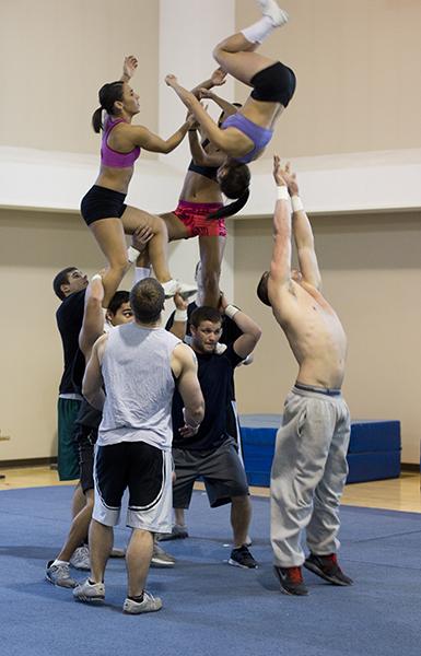 Men on the Sacramento State cheerleading team hold up the women
after completing a stunt. The men are required to be in excellent
shape to hoist up team members.
