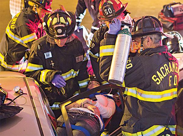 Sacramento firefighters remove an unidentified woman from her parkedcar after she was pinned inside following a crash in parking structure two today.
