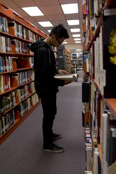 Senior Sandarung Taing, biology major, searches for a book he needs in the Hellenic Collection.

