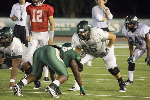 Sac State football offensive lineman No. 65, Vince Weaver, and Line Backer #44, Darnell Sankey, run mock drill at Wednesday night practice at Hornet Stadium.
