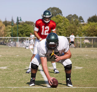 Sacramento State senior offensive lineman Clay DePauw prepares to snap the ball to sophomore starting quarterback Garrett Safron during practice on Sept. 25. Linemen like DePauw play an integral role protecting the offensive backfield during games, but their labors often go unsung.
