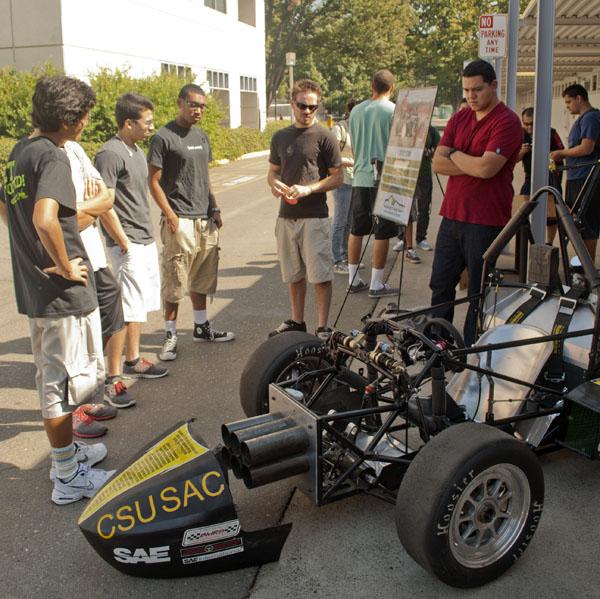 The Hornet Racing Team inspects the design of their new kart. They intend to compete next summer.
