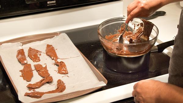 After you have dipped the bacon in chocolate - and have added sprinkles - place the strips on a baking sheet covered in wax paper and refrigerate them for 15 minutes or until the chocolate has hardened.
